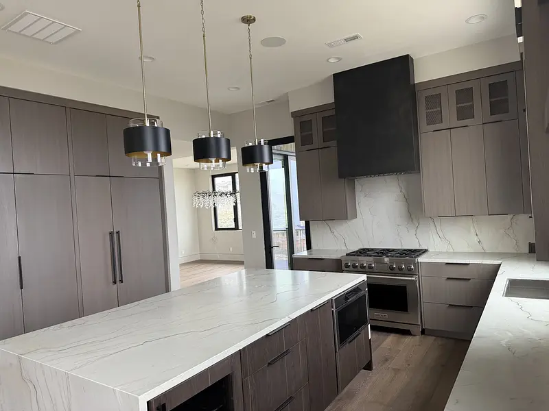 Finished kitchen with smooth wall and ceiling paint around walnut cabinets